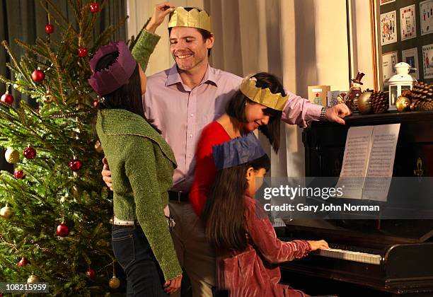 family around piano - christmas crown stock pictures, royalty-free photos & images