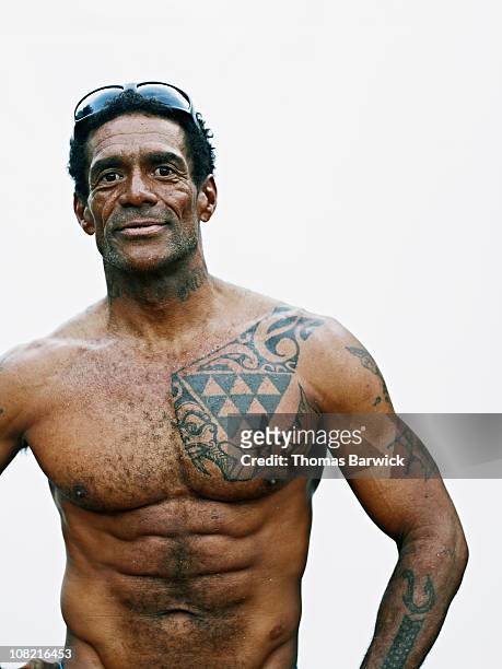 Man with tattoos standing against white background