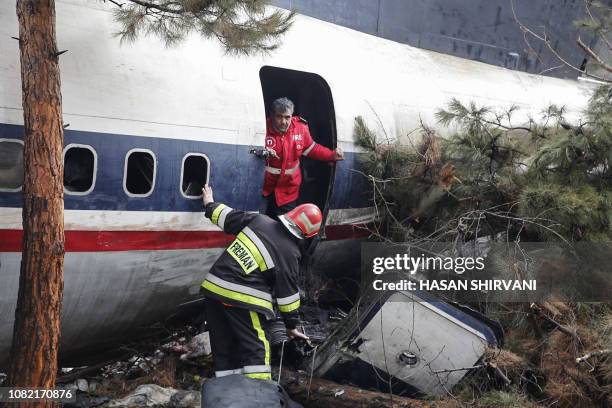 Firefighters and security forces gather amidst the debris of a Boeing 707 cargo plane that reportedly crashed into a residential complex near the...