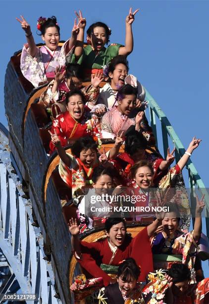 Twenty-year-old Japanese women dressed in kimonos take a ride on a roller-coaster after their "Coming-of-Age Day" celebration ceremony at Toshimaen...