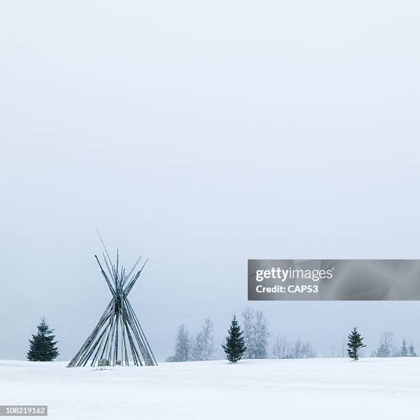 native tepee frame during winter snowstorm - teepee stock pictures, royalty-free photos & images
