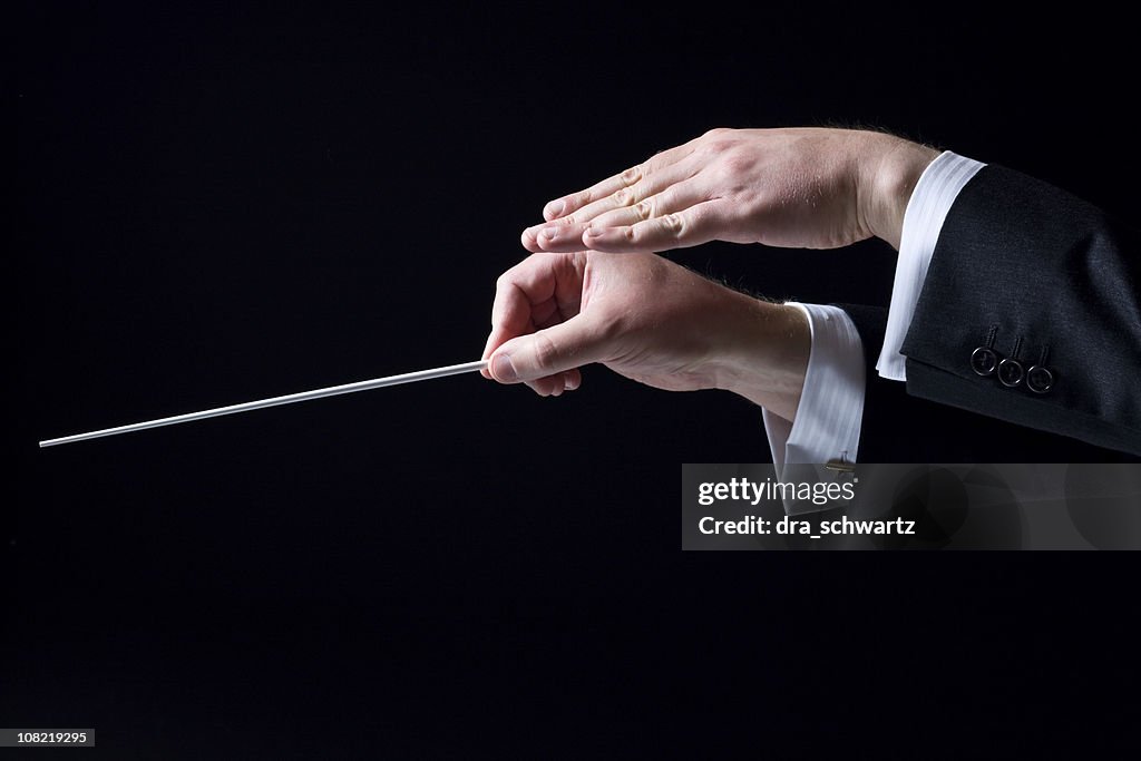 Gros plan de mains de chef d'orchestre orchestre, isolé sur fond noir