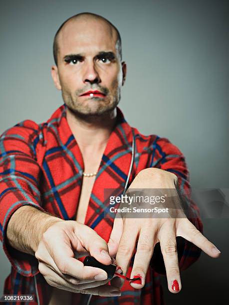 man applying red nail polish - red nail polish stockfoto's en -beelden