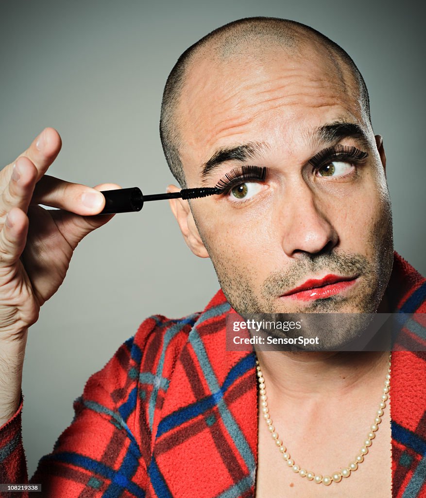 Young Man Applying False Eyelashes and Mascara