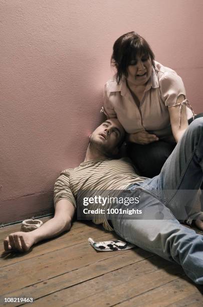 atormentado mulher ajoelhada ao lado overdosed jovem com seringa - drug abuse - fotografias e filmes do acervo