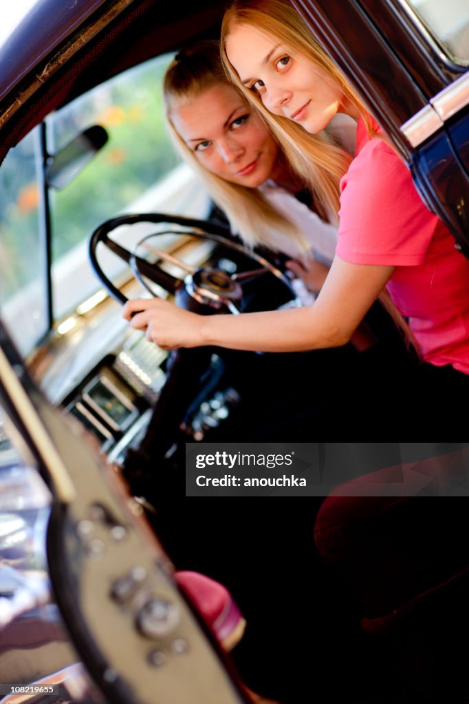 Young Woman and Friend Driving Old Vintage Car