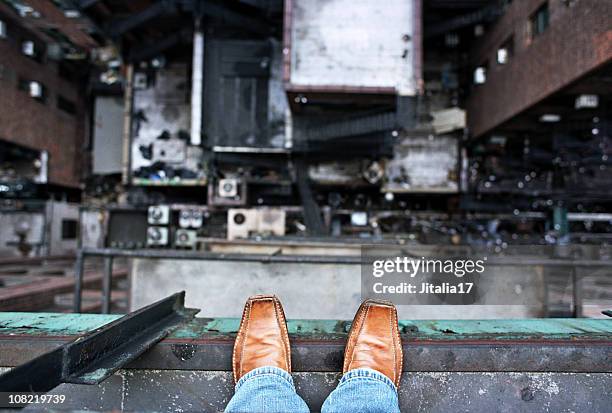 man looking down from a high ledge - suicide concept - zelfmoord stockfoto's en -beelden