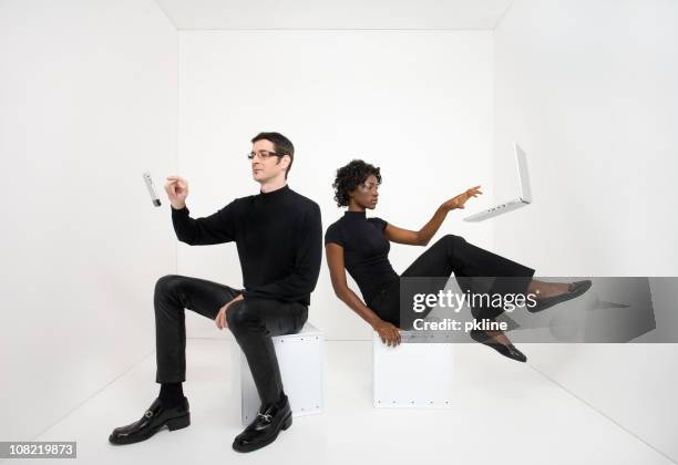 hombre y mujer usando dispositivos electrónicos flotante - levitación fotografías e imágenes de stock