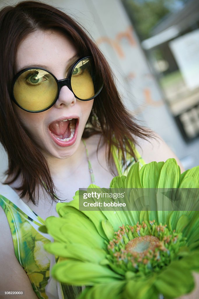 Young Woman Wearing Big Sunglasses Holding Giant Flower