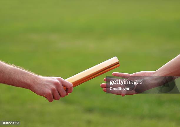 passing the relay baton - relay baton stock pictures, royalty-free photos & images
