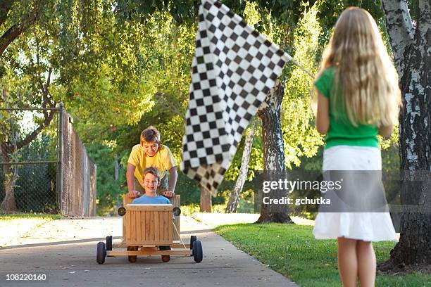 kinder-rennen in push go-cart an einem sonnigen tag - seifenkiste stock-fotos und bilder