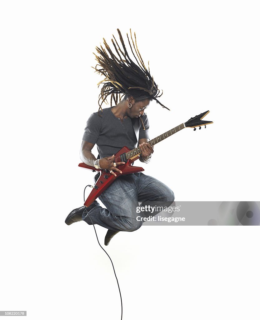 Man playing electric guitar and jumping