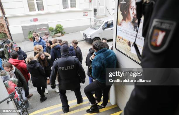 January 2019, Schleswig-Holstein, Lübeck: Two policemen are standing in the entrance to the communal cinema after the screening of the film "Wild...