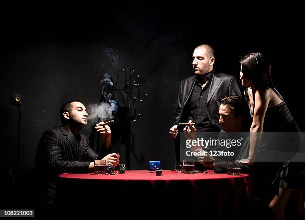 woman watching group of gangster men playing poker - female gangster stock pictures, royalty-free photos & images