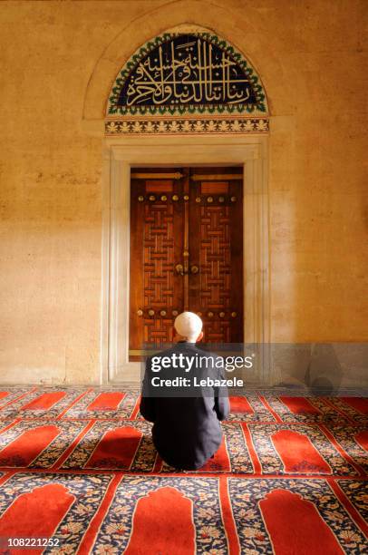 a muslim man praying in a mosque - moskee stockfoto's en -beelden