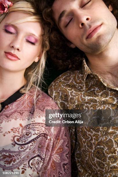 young couple closing eyes and leaning on each other - 70s eye makeup stockfoto's en -beelden