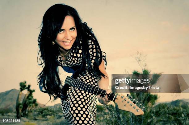 ragazza suona la chitarra nel deserto - rockabilly foto e immagini stock