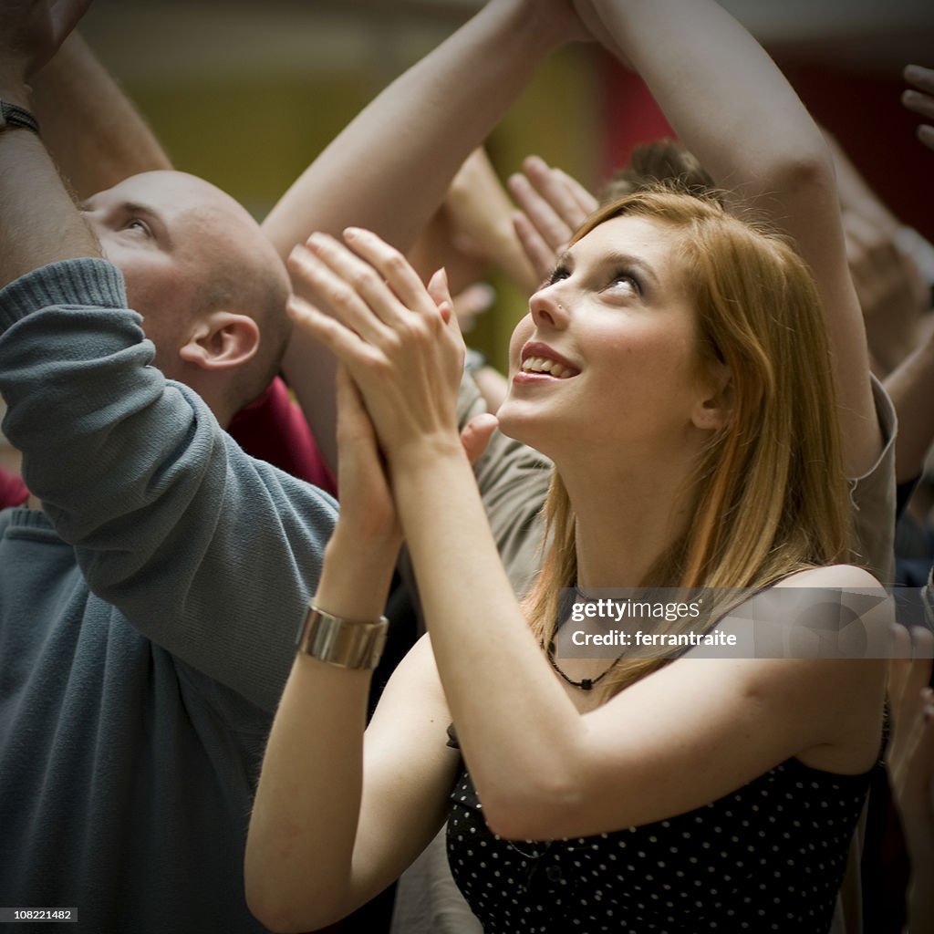 Young Woman Standing in Crowd and Clapping