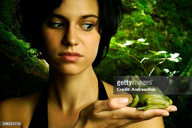 joven mujer sosteniendo y mirando a la rana - prince andreas fotografías e imágenes de stock