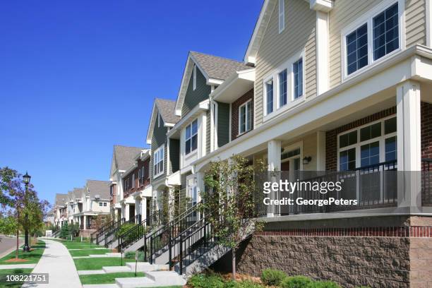 row of townhouses on suburban street - suburban apartments stock pictures, royalty-free photos & images
