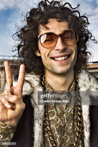 hippy giovane uomo facendo segno di pace con le mani - stile di vita alternativo foto e immagini stock