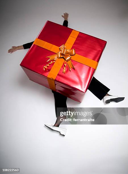 woman crushed beneath huge wrapped present - wrapping arm stock pictures, royalty-free photos & images