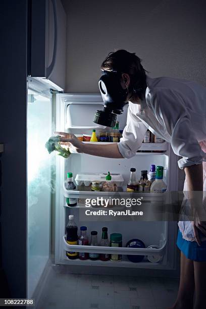 woman cleaning toxic waste glowing fridge - housework humour stock pictures, royalty-free photos & images