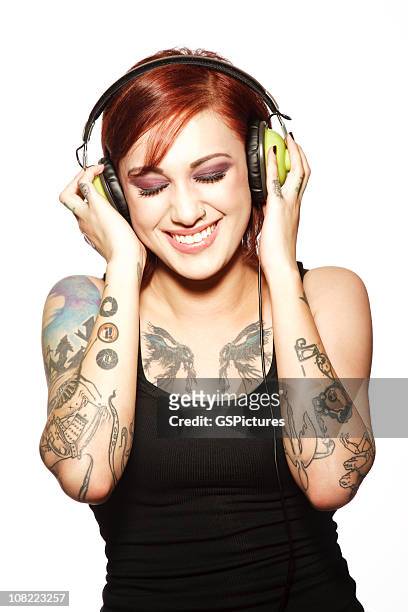 smiling young woman with tattoos listening to headphones - headphones white background stock pictures, royalty-free photos & images