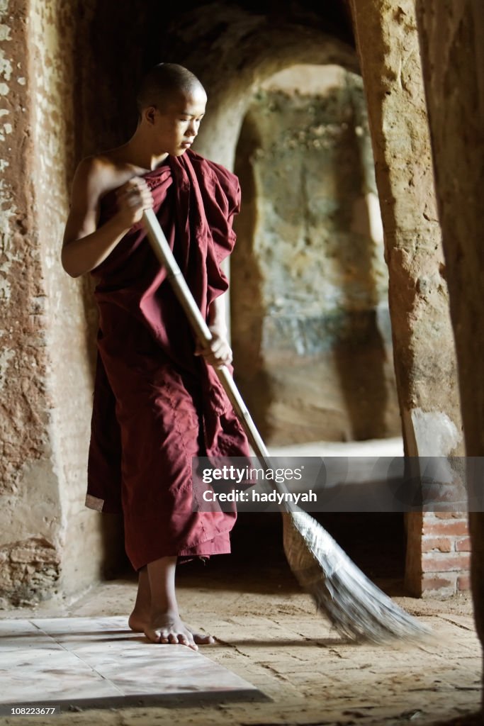 Buddhist monk sweeping temple