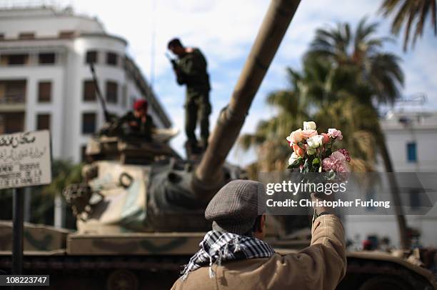 Demonstartor offers flowers to soldiers on their tank as an un-easy peace hangs over Tunisia on January 21, 2011 in Tunis, Tunisia. Tunisians have...