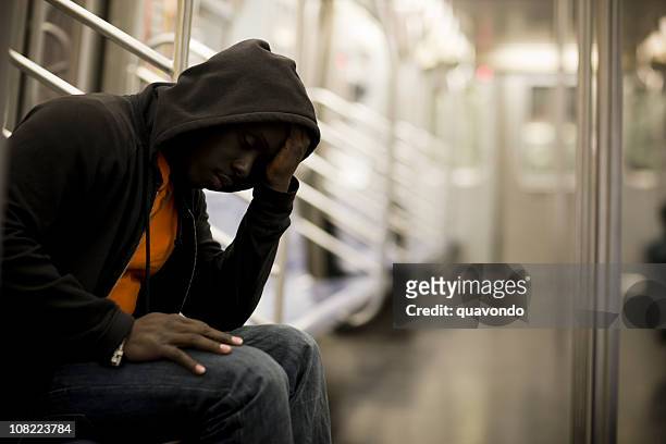 nero uomo con la testa tra le mani su metropolitana, con spazio copia - uomo incappucciato foto e immagini stock