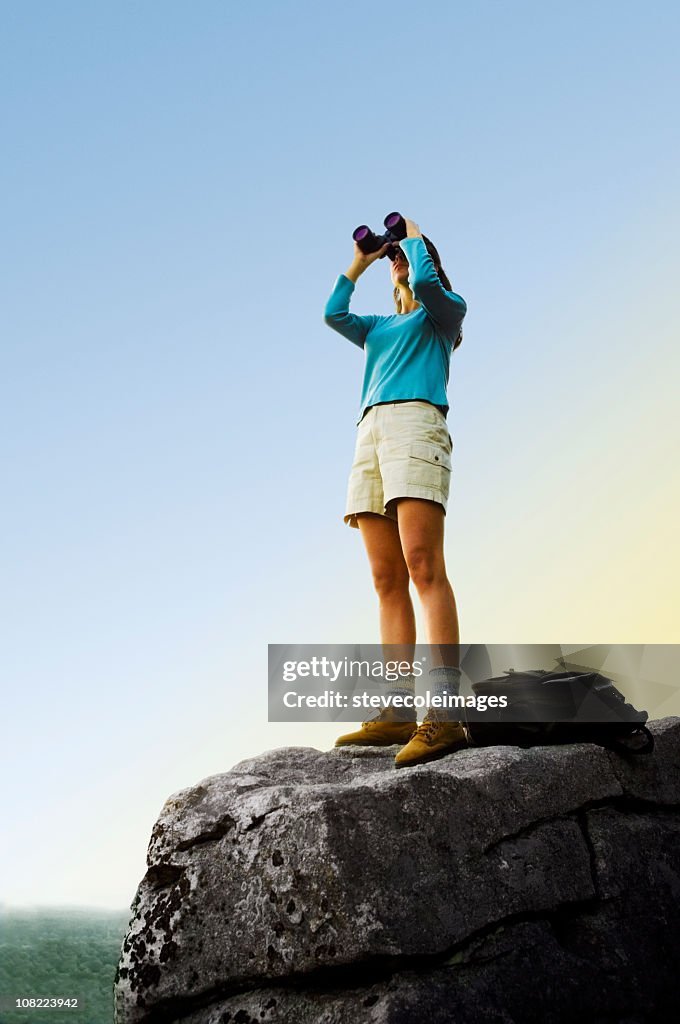 Mulher procurando no topo da montanha