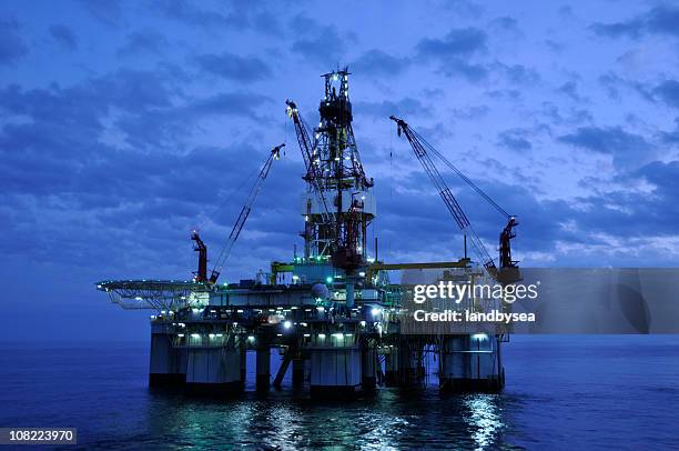 off shore drilling platform at twilight. oil rig and reflection - boortoren stockfoto's en -beelden