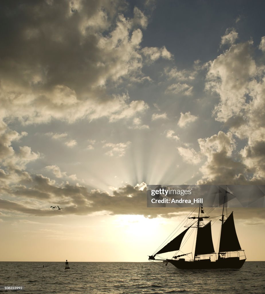 Silhouette of Sailboat on Horizon at Sunset