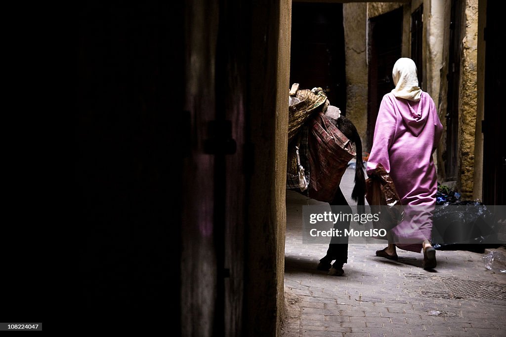 Arab woman walking in a narrow street