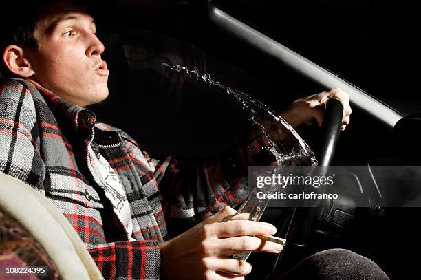 teenage boy drinking beer and spilling while driving car - drunk driving accident stock pictures, royalty-free photos & images