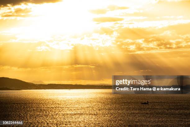 orange-colored morning sunbeam on the beach in kamakura and yokosuka cities and sagami bay, part of northern pacific ocean in japan - 日の出　海 ストックフォトと画像