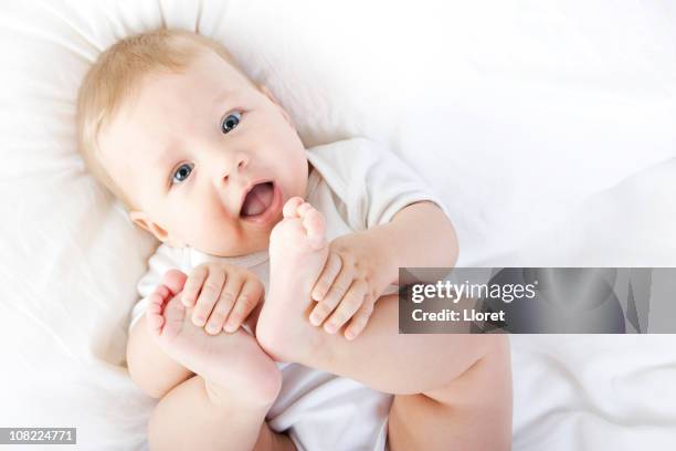 bambino felice giocare con i piedi - supino foto e immagini stock