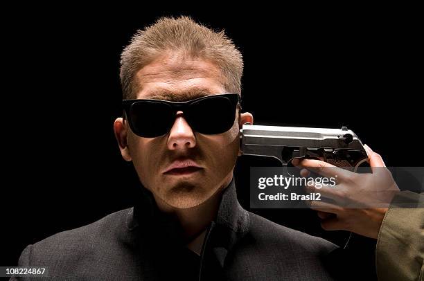 gun being held to mature man's head, isolated on black - fire victim stock pictures, royalty-free photos & images