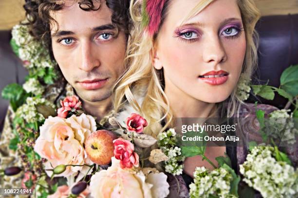 young couple posing with flowers - 70s eye makeup stockfoto's en -beelden