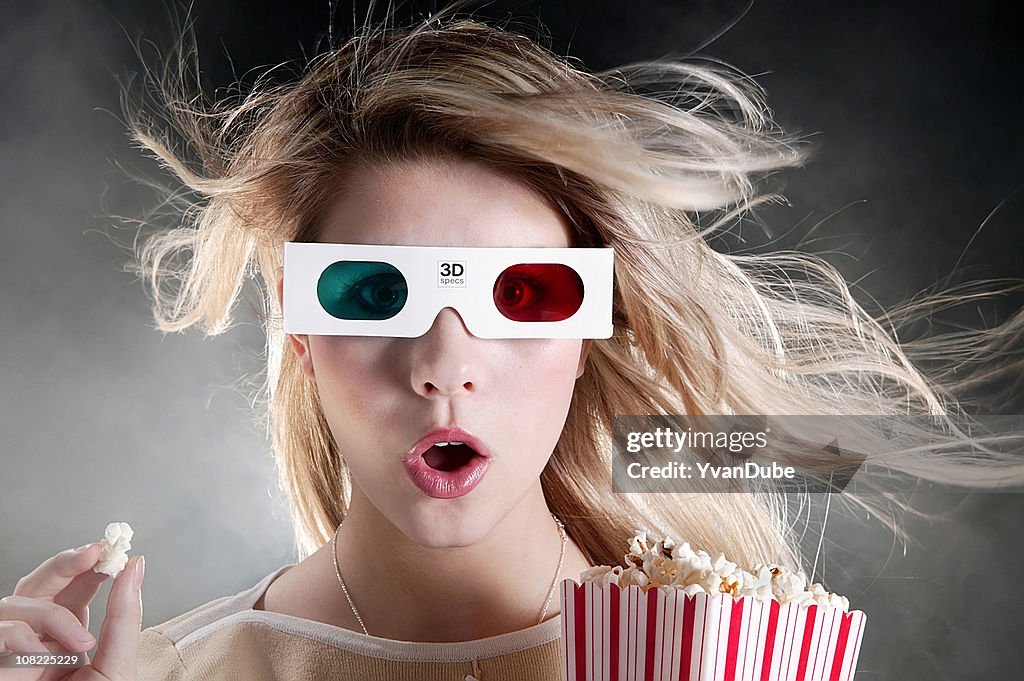 Young woman with 3D movie glasses and popcorn