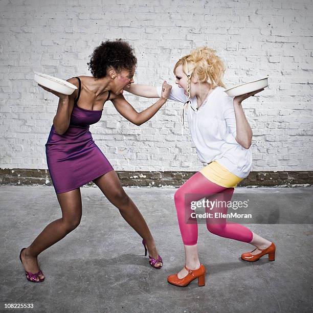 two young women about to throw pies at each other - food fight stock pictures, royalty-free photos & images