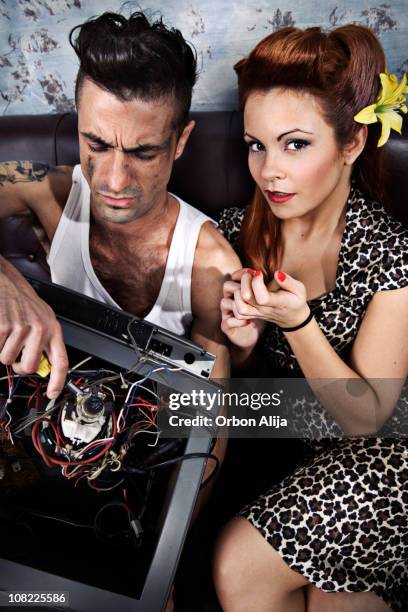 homme de réparer une télévision et femme manucure pour elle - rockabilly stock photos et images de collection