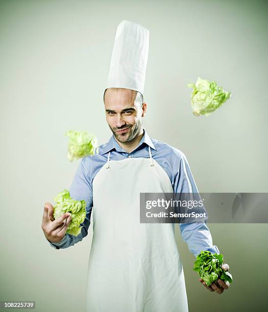 young man chef juggling lettuce heads - funny vegetable stock pictures, royalty-free photos & images