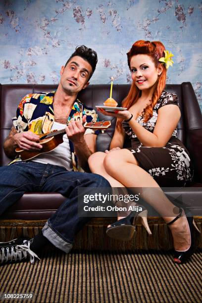 rocker couple jouant ukulélé et tenant gâteau avec bougies - rockabilly stock photos et images de collection