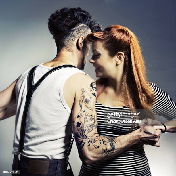 rockabilly man and woman holding hands dancing - rockabilly stockfoto's en -beelden