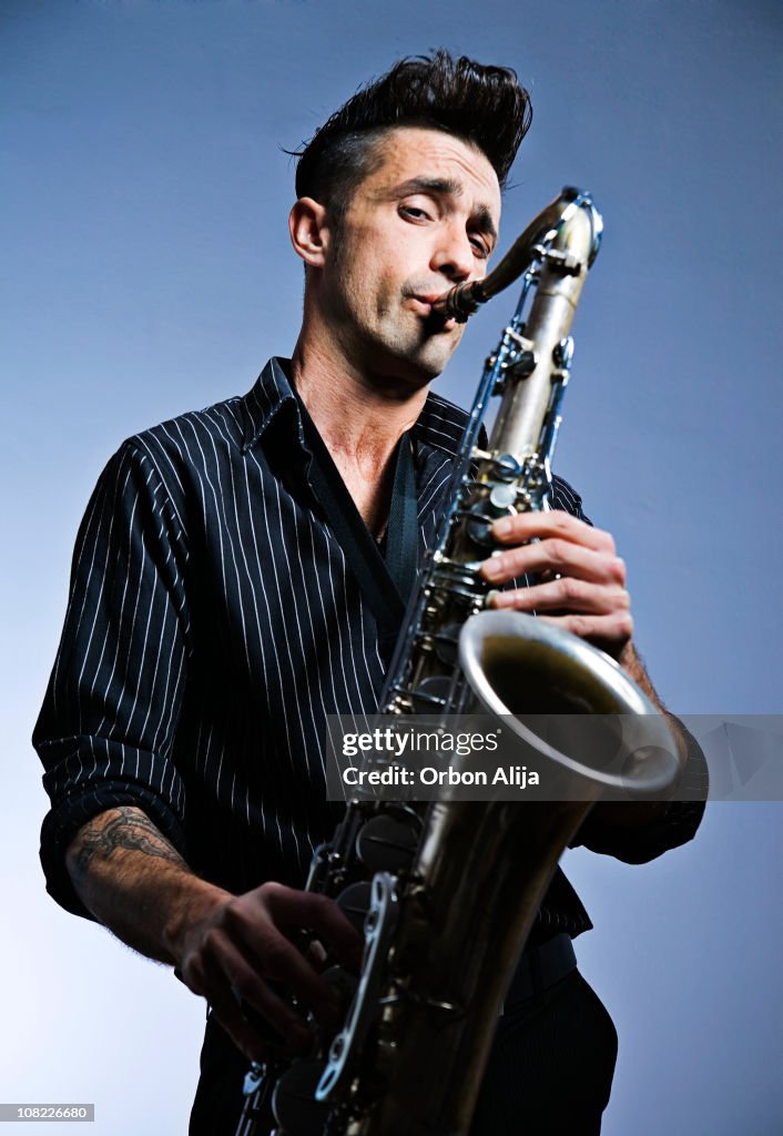 Hombre tocando el saxofón en fondo azul