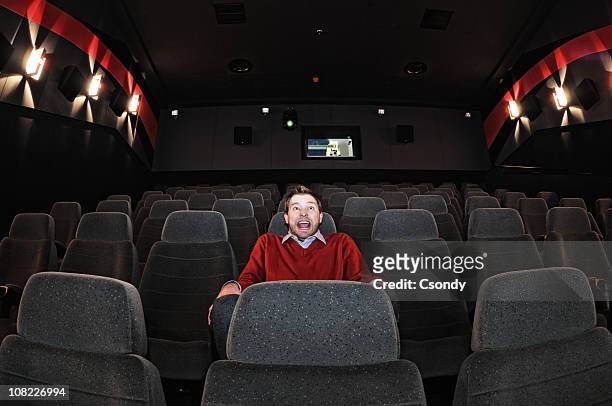 scared man sitting the movie theatre alone - arts express yourself 2009 stock pictures, royalty-free photos & images