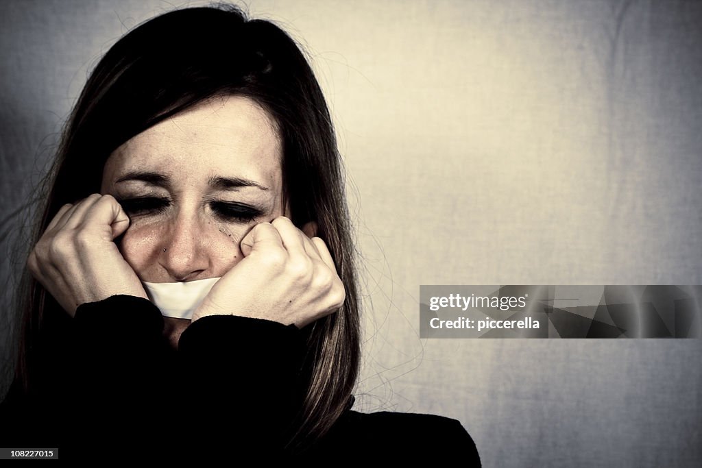 Crying Woman with Tape Covering Mouth