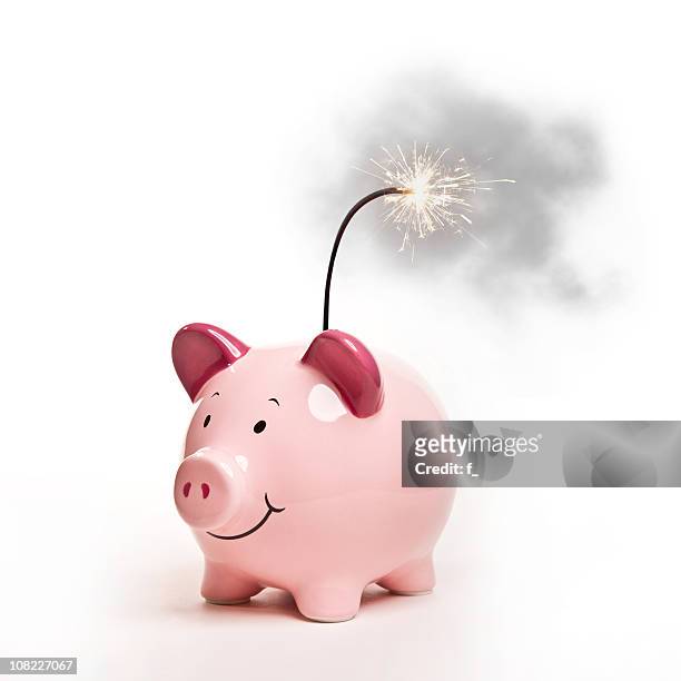 piggy bank with lit bomb fuse, isolated on white - bom stockfoto's en -beelden